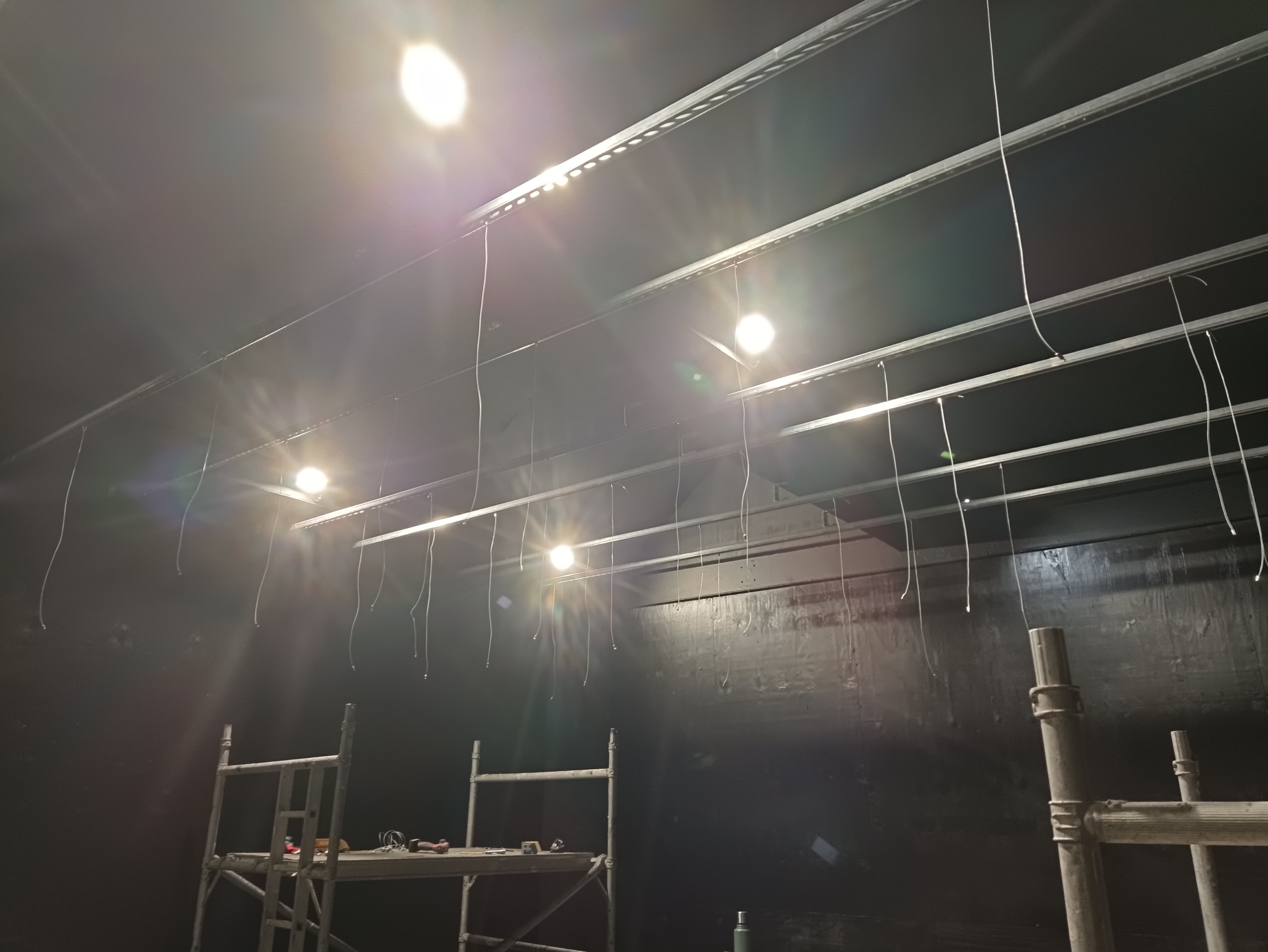 Steel suspension wires attached to Unistrut for a suspended gym lighting installation