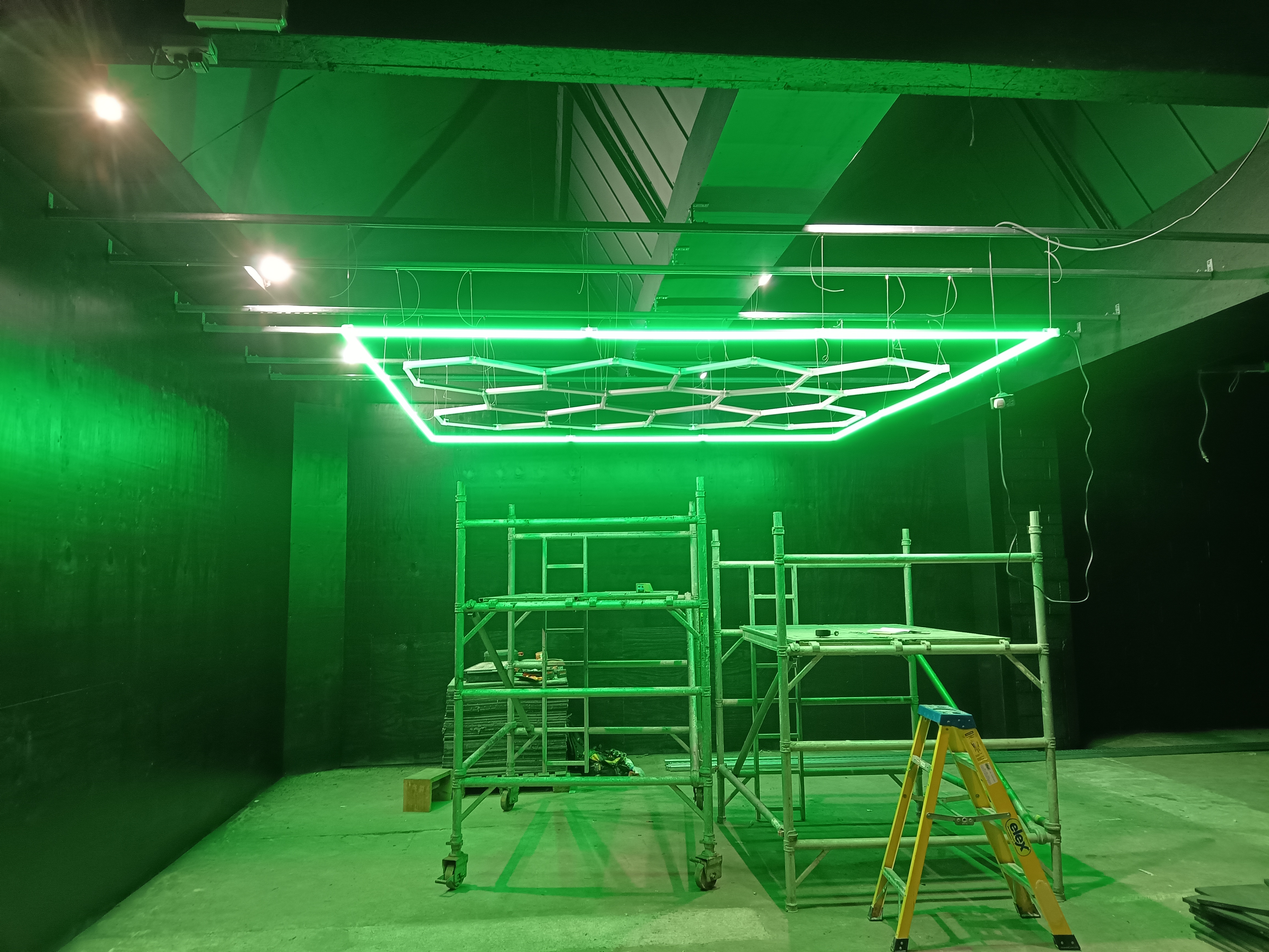 Suspended honeycomb LED lighting installation switched on inside a gym