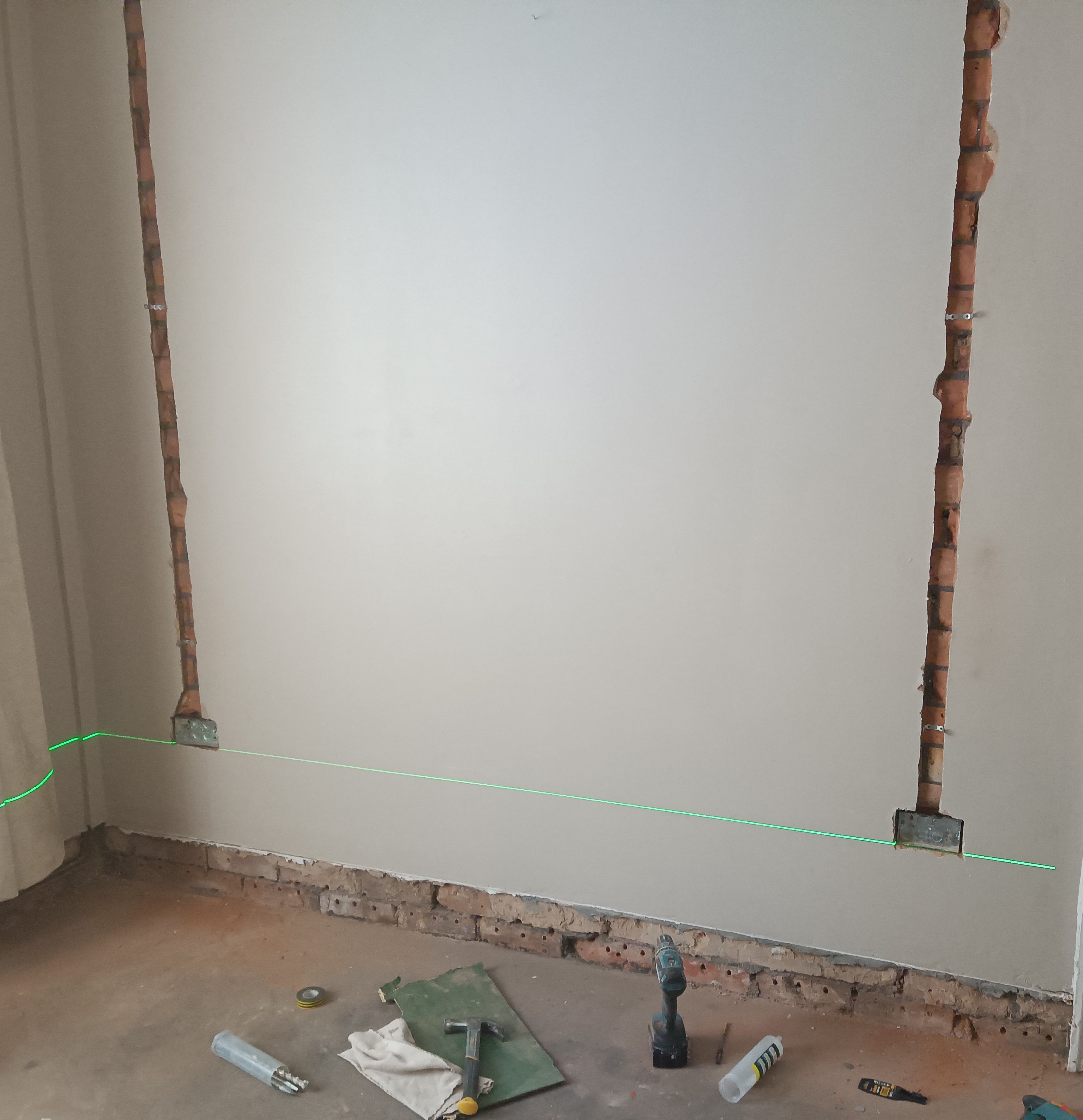Socket backbox being positioned level during a domestic socket circuit rewire in Preston