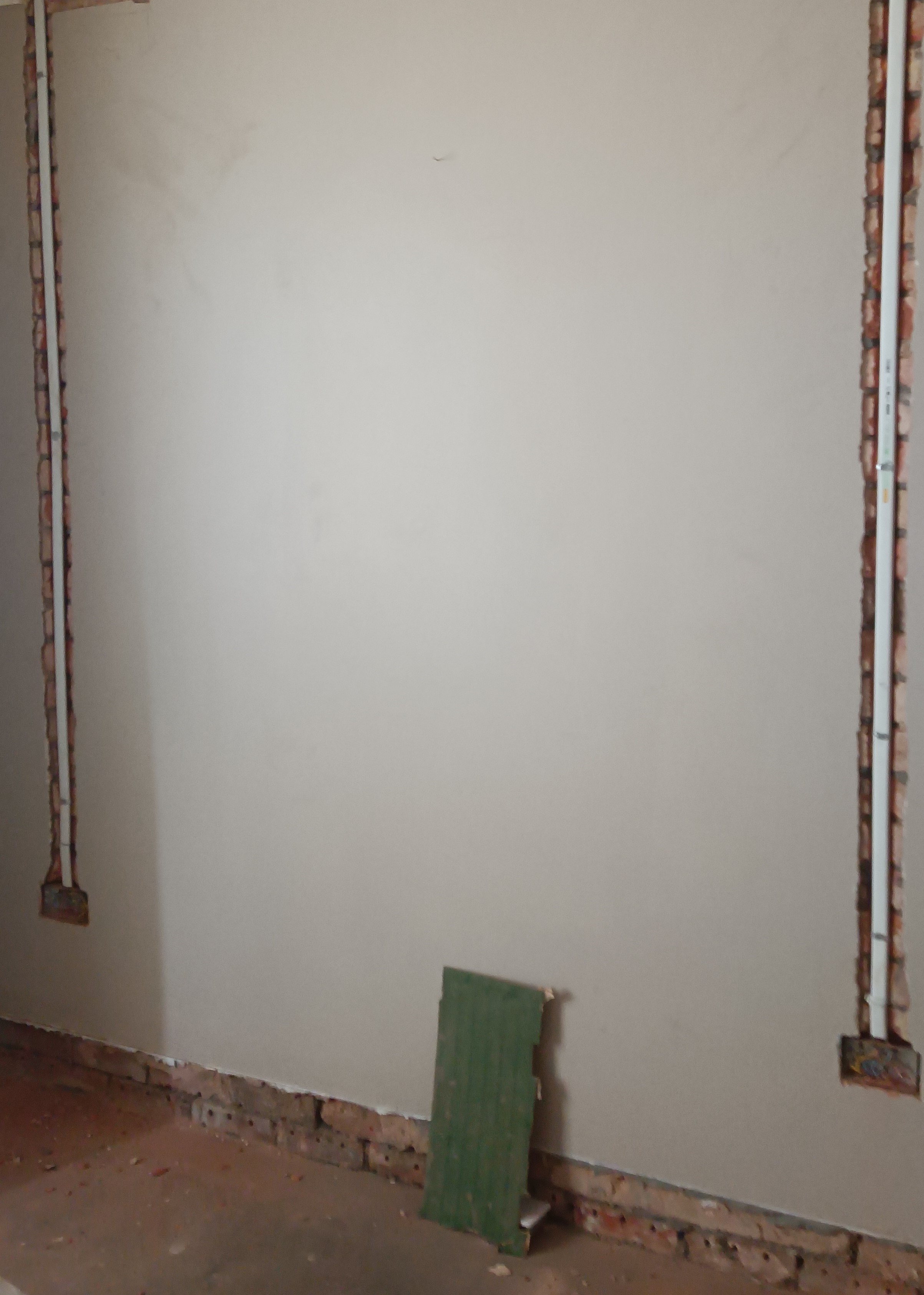 Oval conduit installed in chased brickwork for new socket wiring
